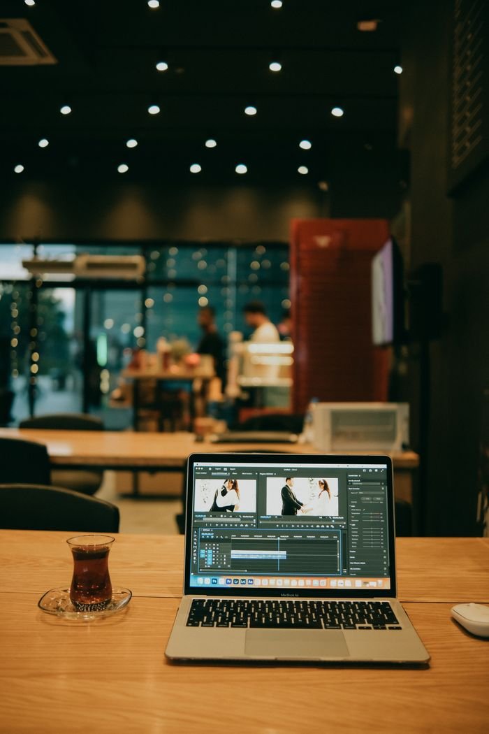 Edit videos on a laptop in a cozy office setting with Turkish tea.